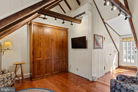 a bedroom with a bed and a flat tv screen on the dresser