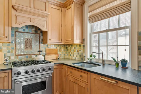 a kitchen with granite countertop a sink stainless steel appliances and cabinets
