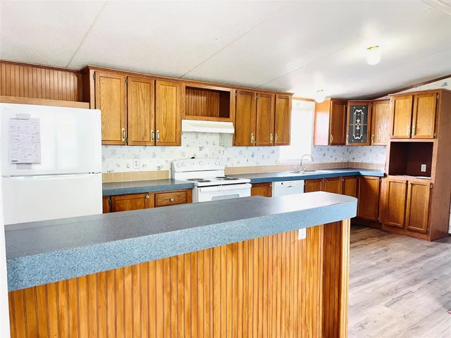 a kitchen with stainless steel appliances granite countertop a sink window and cabinets