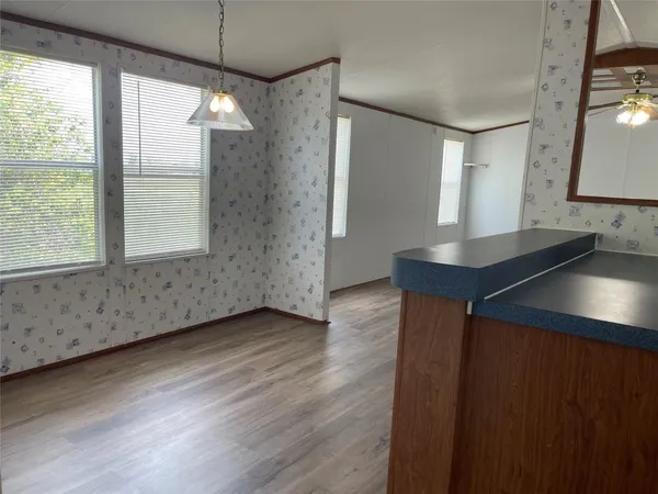 a view of an empty room with window and wooden floor