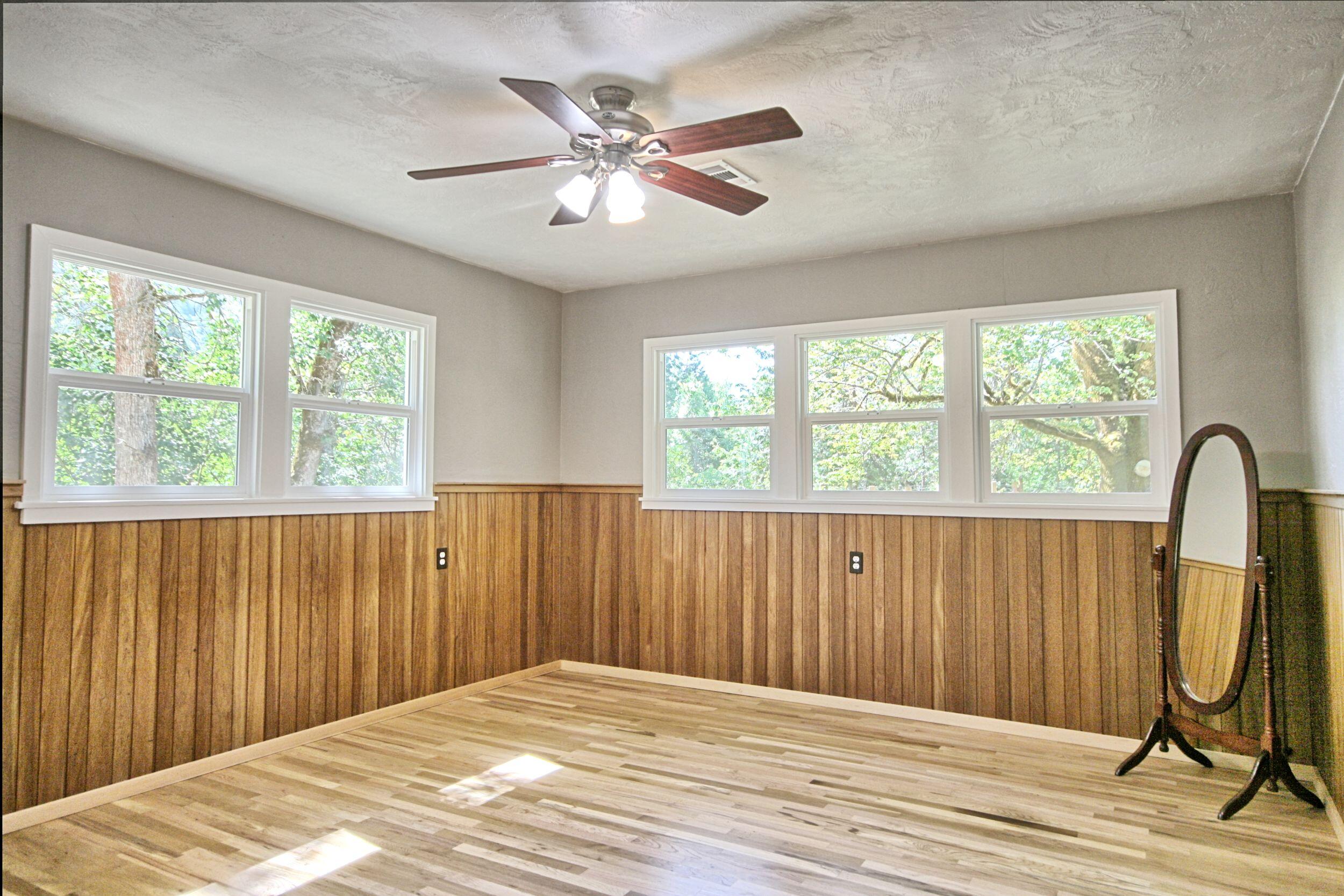 199 Powell Creek Road Williams, OR 97544 - Photo 28 of 57 a view of a bedroom with wooden floor and fan