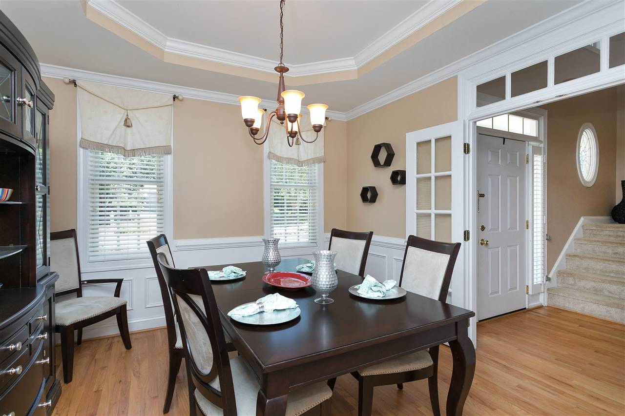 Lovely Dining room large and bright with gorgeous trey ceiling, custom moldings, transom windows above entry and hardwood floors! Dining Room