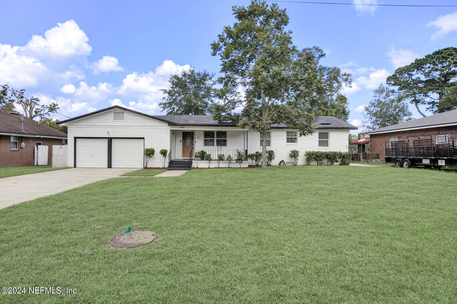 a front view of a house with a yard and trees