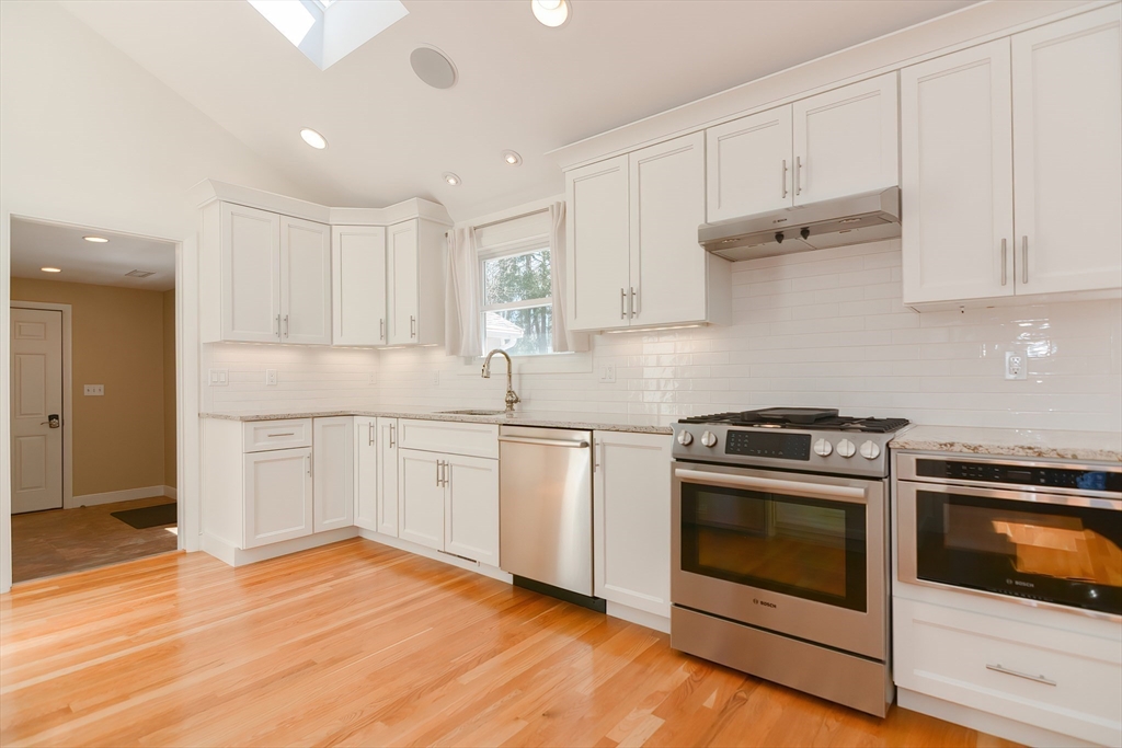 2054 Main Street Concord, MA 01742 - Photo 14 of 41 a kitchen with granite countertop wooden floors and white stainless steel appliances