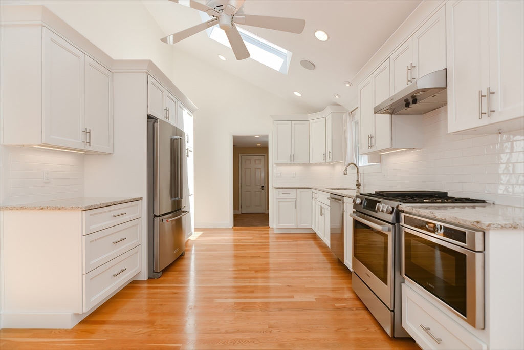 2054 Main Street Concord, MA 01742 - Photo 16 of 41 a kitchen with stainless steel appliances white cabinets and wooden floor