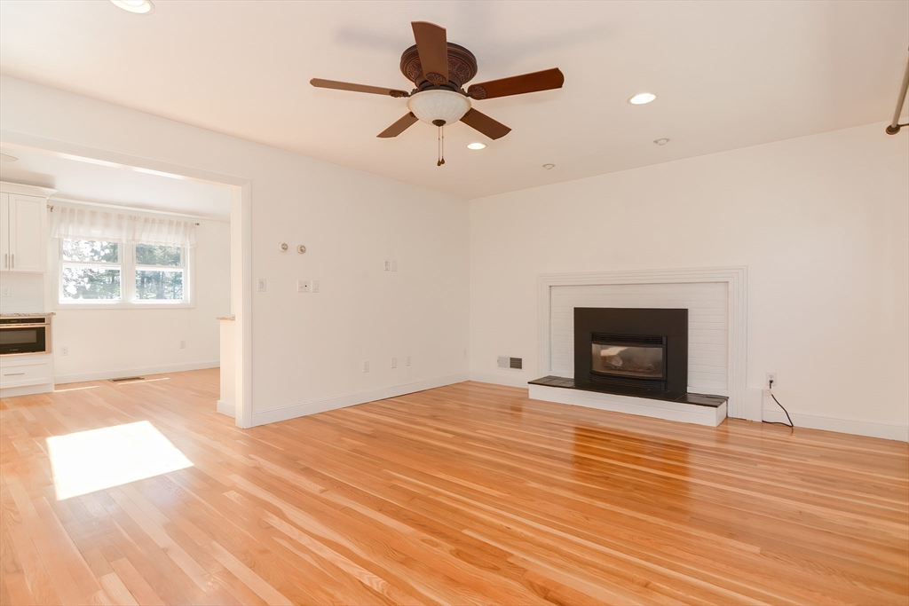 2054 Main Street Concord, MA 01742 - Photo 21 of 41 a view of empty room with wooden floor and fireplace
