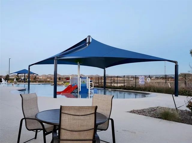 a view of patio with a table and chairs under an umbrella