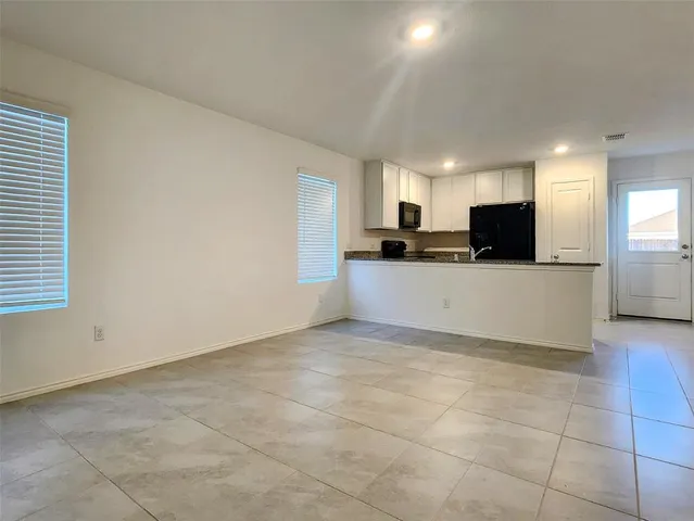 a kitchen with granite countertop a sink and white cabinets
