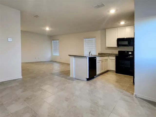 a view of kitchen with stainless steel appliances a refrigerator and a stove top oven