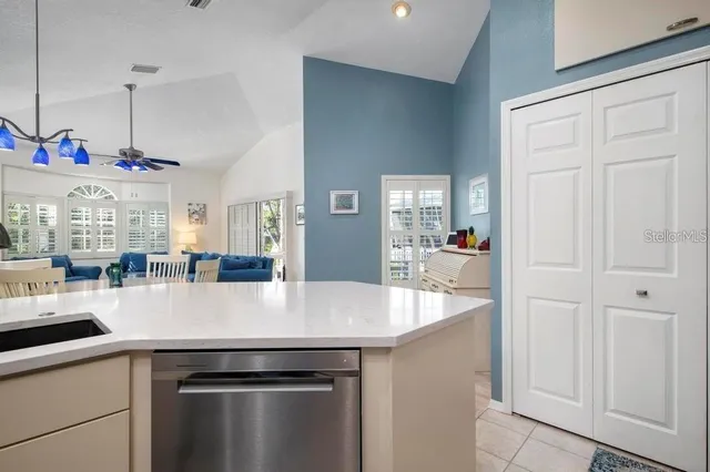 a view of a kitchen with kitchen island a sink a counter space and stainless steel appliances