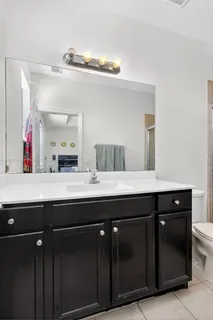 a bathroom with a sink a toilet a mirror and shower