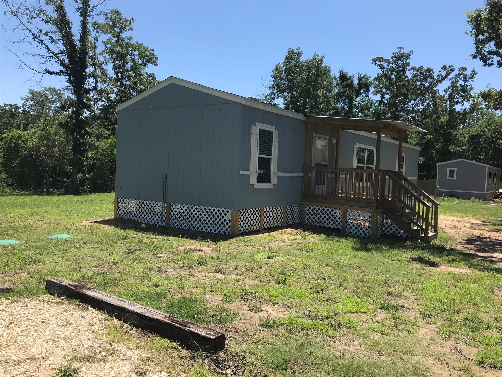 246 Brenda Road Trinity, TX 75862 - Photo 4 of 28 a backyard of a house with wooden fence and large trees