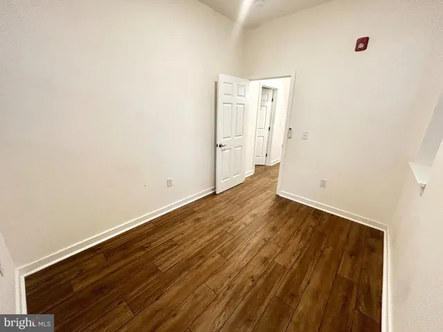 a view of a room with wooden floor and white walls