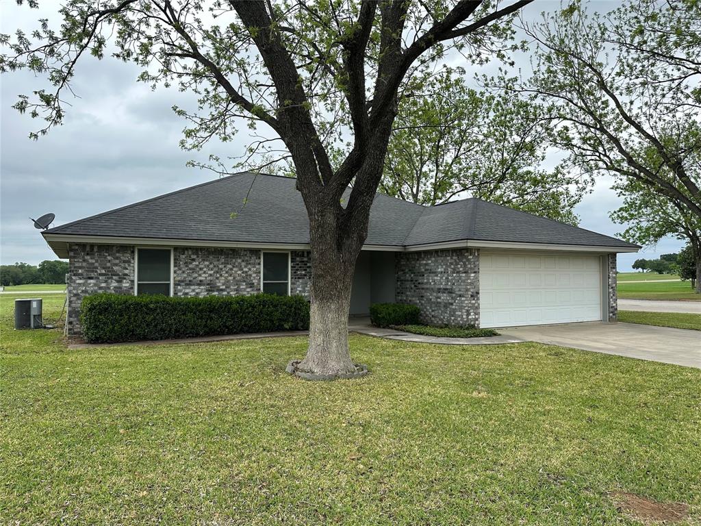101 Player Street Comanche, TX 76442 - Photo 1 of 4 a front view of a house with a yard and garage