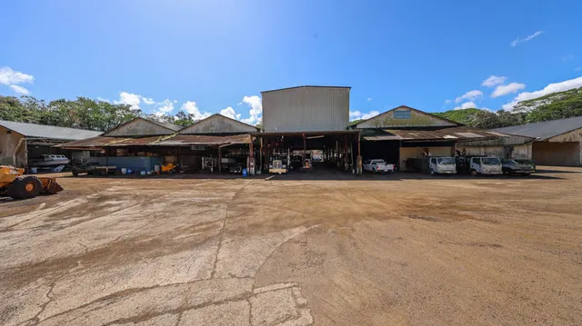 a view of a big house with table and chairs under an umbrella