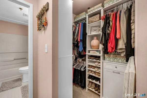 a view of walk in closet with clothes and shoes