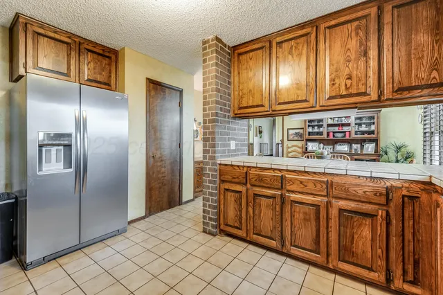 a kitchen with stainless steel appliances granite countertop a refrigerator and cabinets