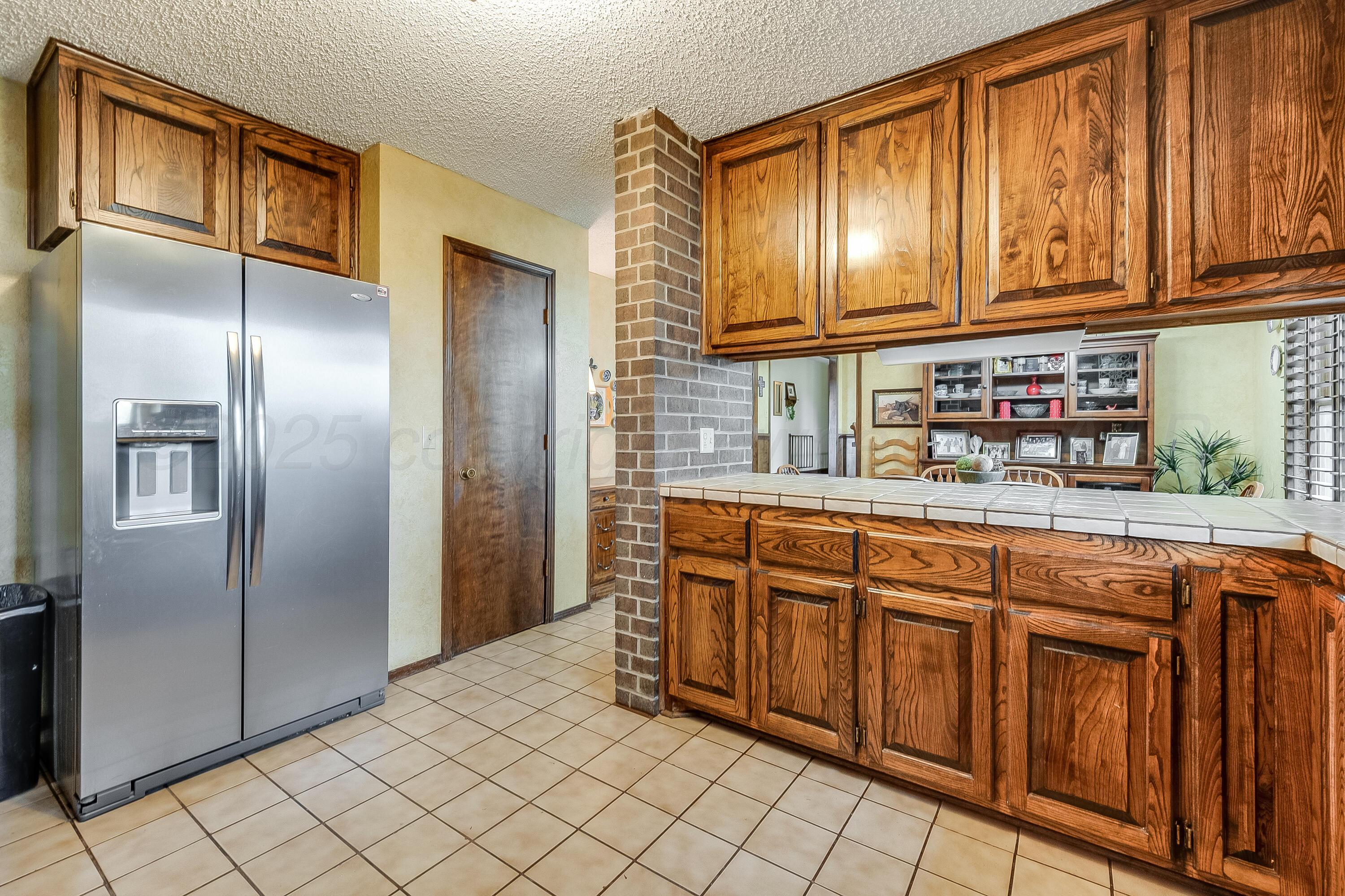300 West 11th Street Wheeler, TX 79096 - Photo 16 of 49 a kitchen with stainless steel appliances granite countertop a refrigerator and cabinets