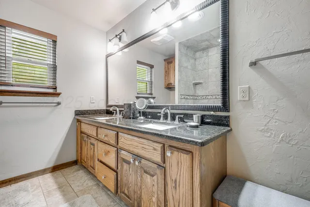 a bathroom with a granite countertop sink mirror and a toilet