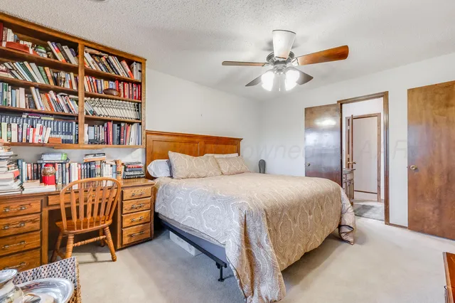 a bedroom with a bed and a book shelf