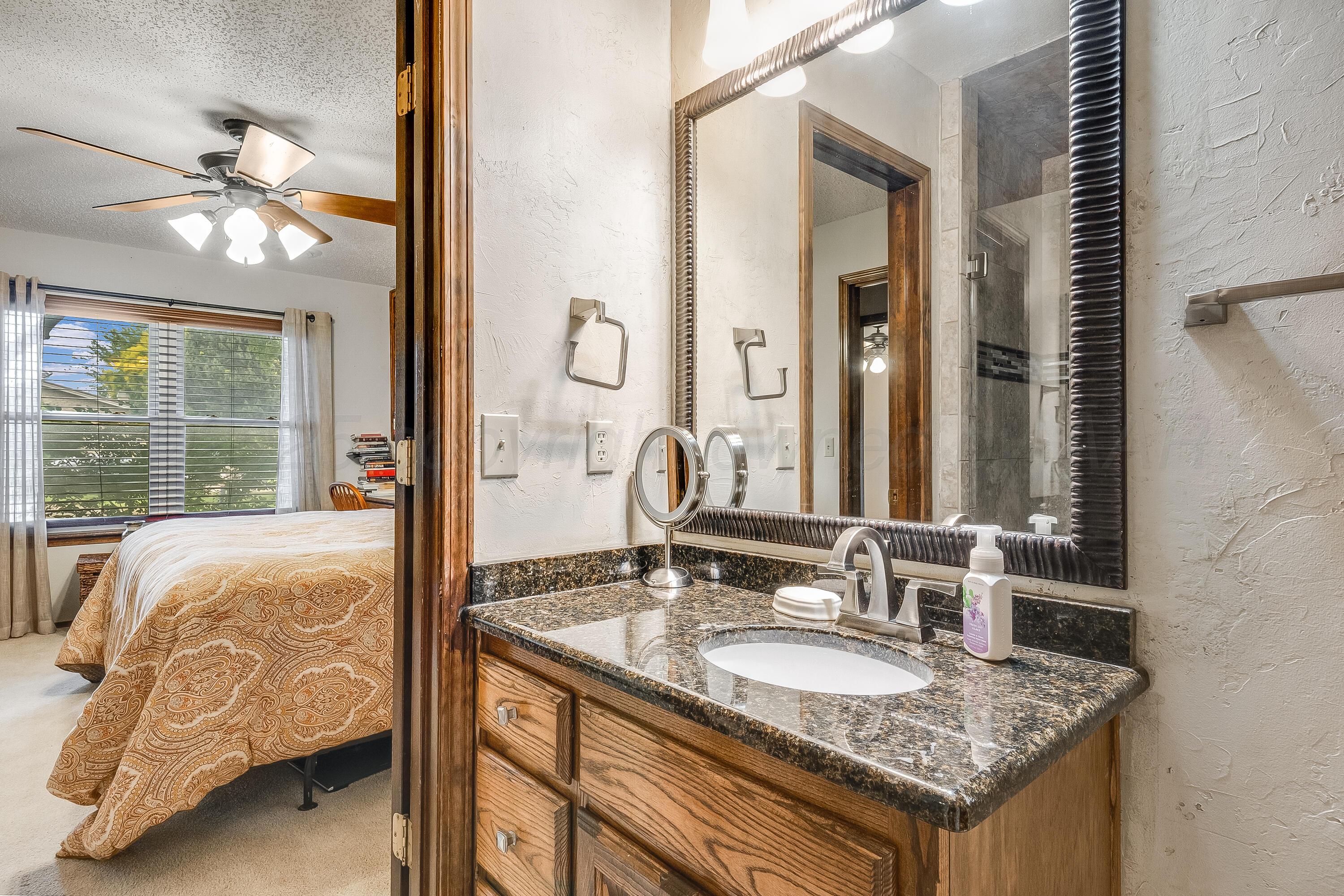 300 West 11th Street Wheeler, TX 79096 - Photo 34 of 49 a bathroom with a granite countertop sink and a mirror