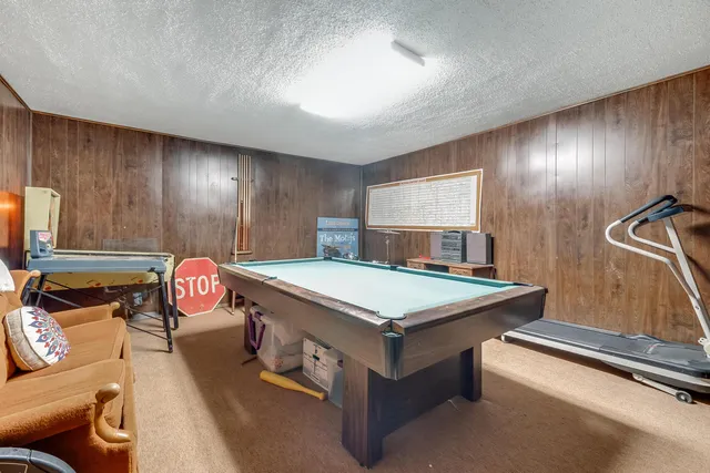 a room with pool table and a projector screen