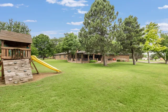 a view of a house with swimming pool and a yard