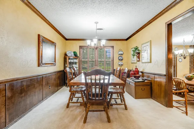 a view of a dining room with furniture and chandelier
