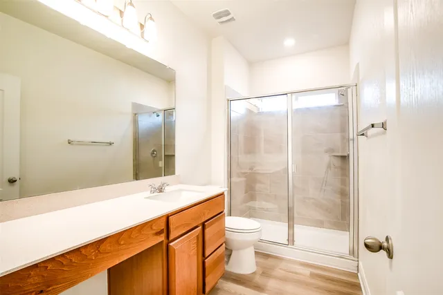 a bathroom with a double vanity sink toilet and shower
