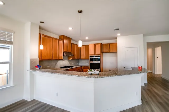 a kitchen with kitchen island granite countertop a sink cabinets and window