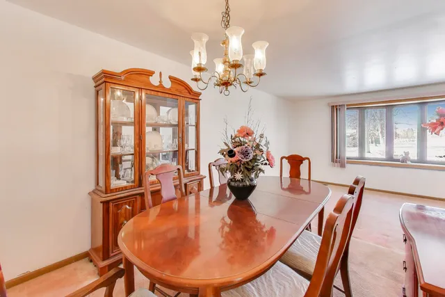 a dining room with furniture a chandelier and window