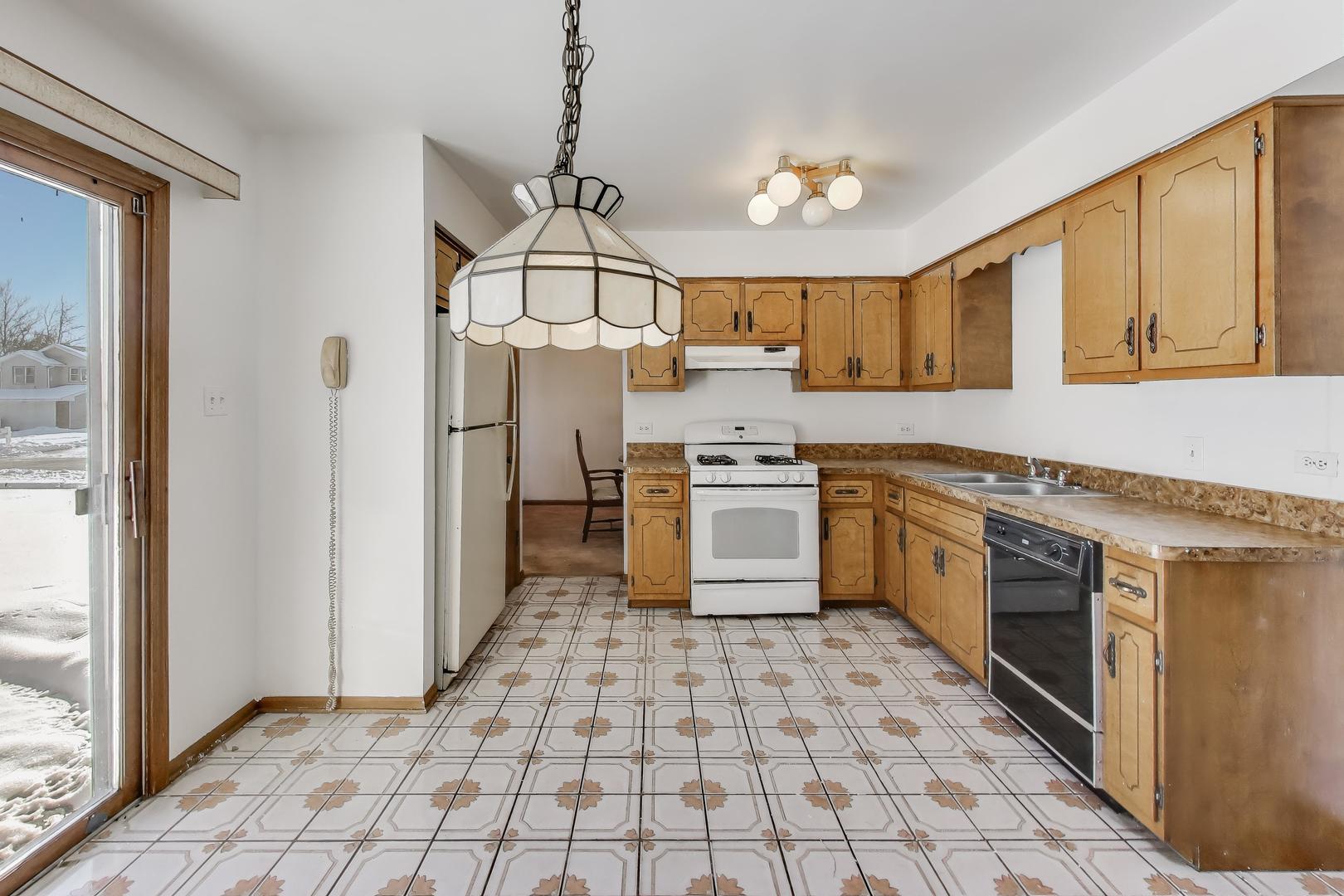 749 Old Farm Road Matteson, IL 60443 - Photo 10 of 34 a kitchen with stainless steel appliances granite countertop a stove a sink and a refrigerator