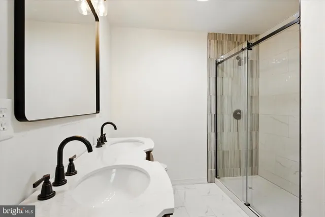 a bathroom with a shower sink and mirror