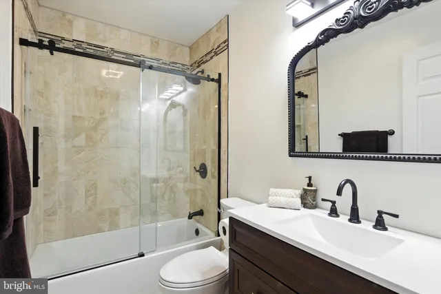 a bathroom with a double vanity sink toilet mirror and shower