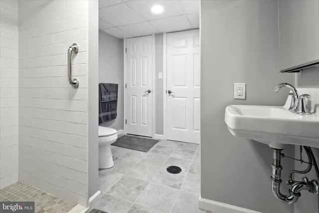 a bathroom with a sink a toilet and shower