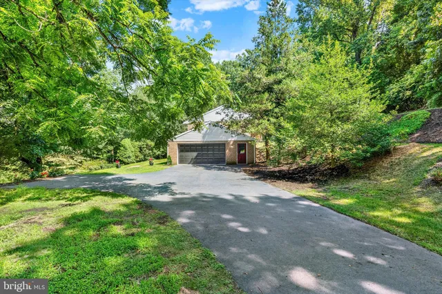 a front view of a house with a yard and a tree