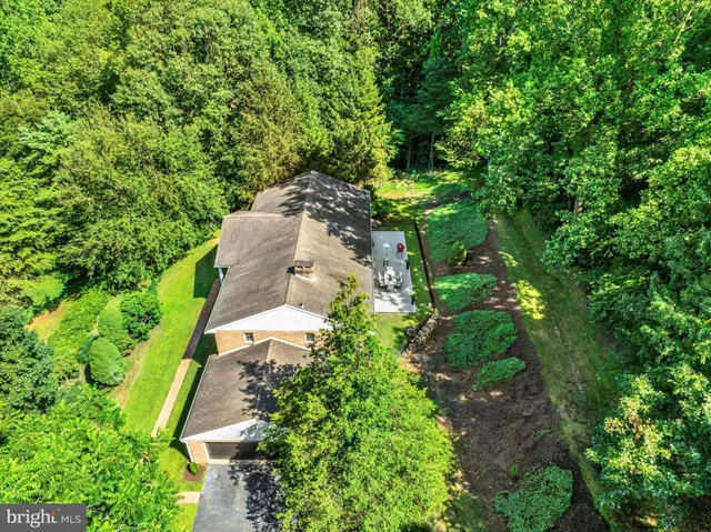 an aerial view of a house with a yard and outdoor seating
