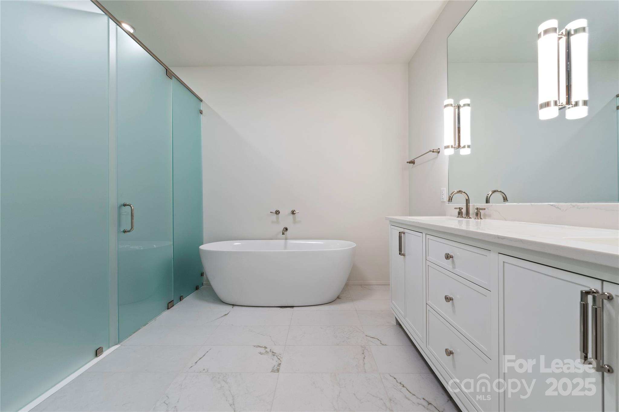 1500 Queens Road, Unit 204 Charlotte, NC 28207 - Photo 12 of 33 a spacious bathroom with a bathtub sink and mirror