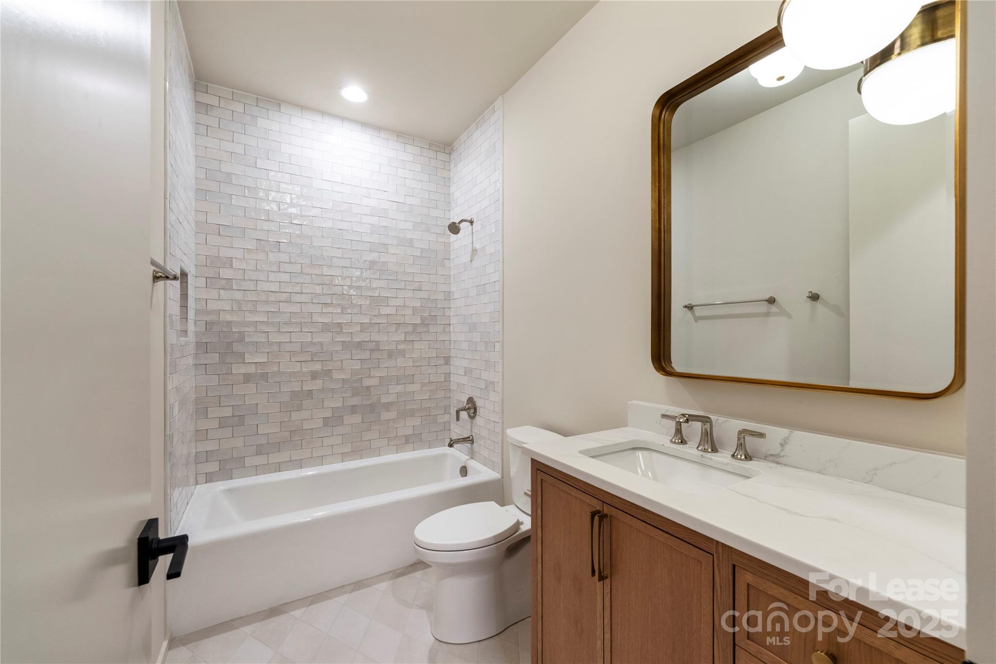 1500 Queens Road, Unit 204 Charlotte, NC 28207 - Photo 16 of 33 a bathroom with a granite countertop sink toilet and shower