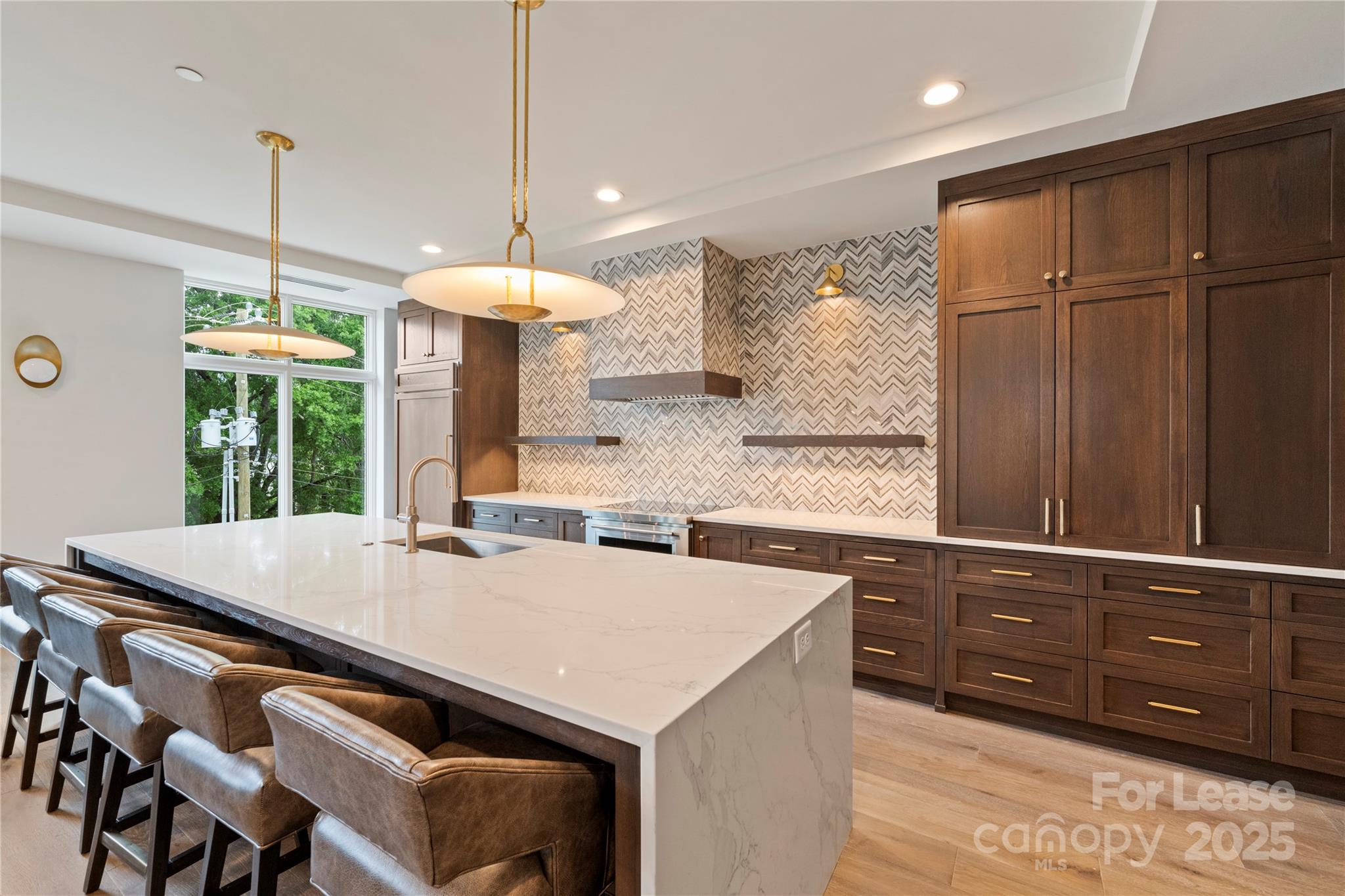 1500 Queens Road, Unit 204 Charlotte, NC 28207 - Photo 9 of 33 a kitchen with a sink a counter and chairs