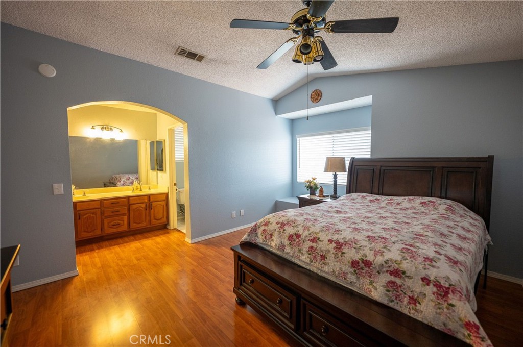 7444 Webster Street Highland, CA 92346 - Photo 23 of 37 a bedroom with a bed and a chandelier