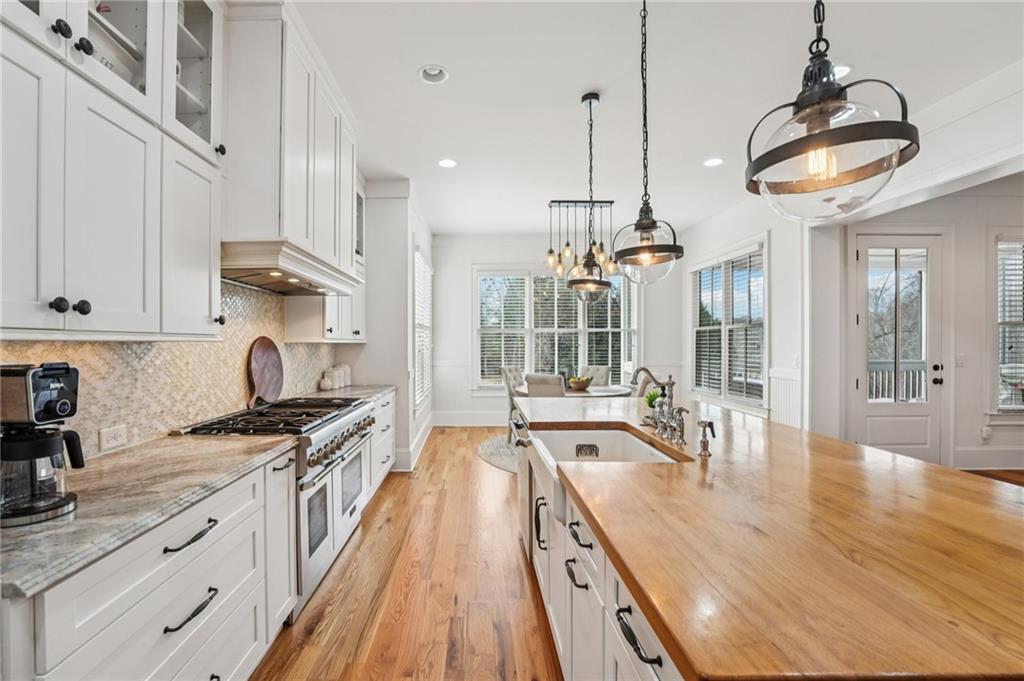 203 Trinity Way Canton, GA 30115 - Photo 12 of 77 a kitchen with stainless steel appliances granite countertop a lot of counter space and wooden floors