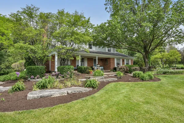 a front view of a house with yard porch and sitting area