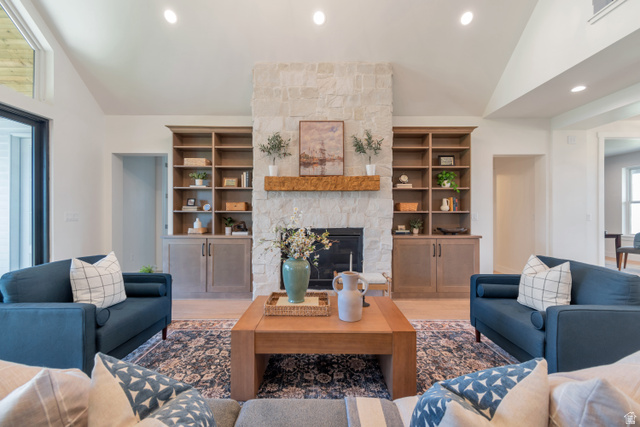 1820 West Farmhouse Flats Road Peoa, UT 84061 - Photo 13 of 79 Living area featuring a stone-clad fireplace with a wood mantel, built-in shelving with lower cabinetry, vaulted ceilings, and recessed lighting