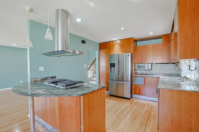 a kitchen with stainless steel appliances granite countertop a sink a stove a refrigerator and cabinets