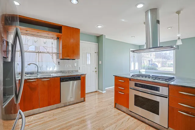 a kitchen with stainless steel appliances granite countertop a stove a sink and a refrigerator