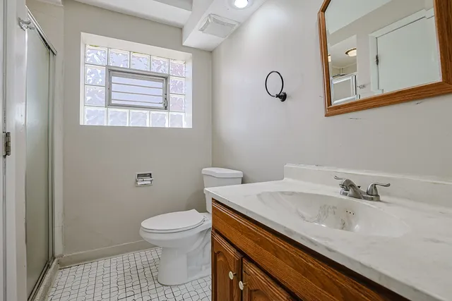 a bathroom with a sink a toilet and a window