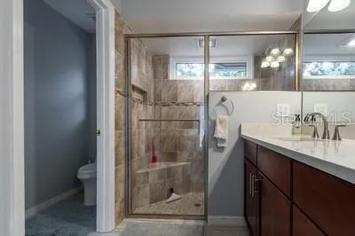a bathroom with a shower sink vanity and toilet
