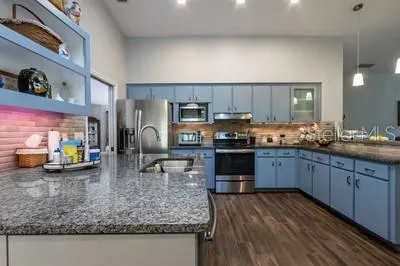 a kitchen with sink refrigerator and cabinets