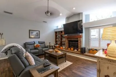 a living room with furniture a flat screen tv and a fireplace